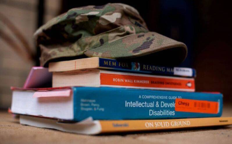 a military hat on a stack of textbooks